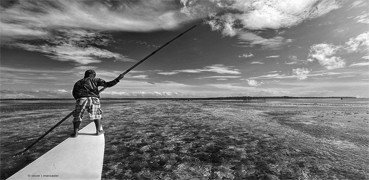 A black and white picture with someone fishing